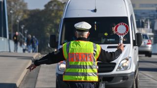 Symbolbild: Ein Beamter der Bundespolizei stoppt einen Fahrer eines Kleintransporters bei der Einreise nach Deutschland (Quelle: dpa/Patrick Pleul)