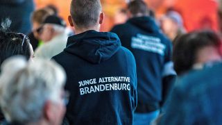 Teilnehmer einer Wahlkampfveranstaltung tragen am 23.09.2022 Kleidung mit der Aufschrift "Junge Alternative Brandenburg". (Quelle: picture alliance/Frank Hammerschmidt)