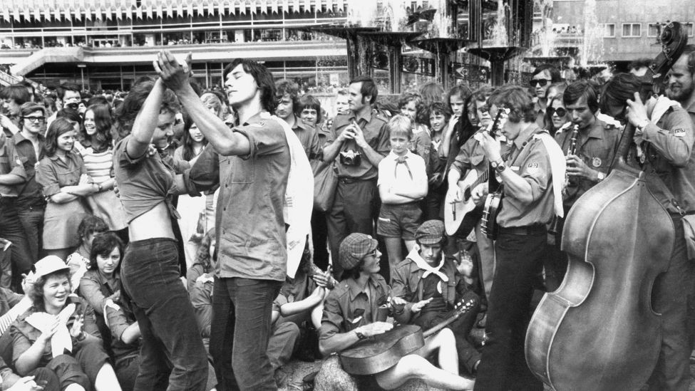 Eine Kapelle der "Freien Deutschen Jugend" (FDJ) spielt auf dem Alexanderplatz im Osten Berlins zu Gesang und Tanz. Vom 28. Juli bis zum 5. August 1973 fanden in der DDR-Hauptstadt die X. Weltfestspiele der Jugend und Studenten mit zahlreichen Veranstaltungen statt. (Quelle: dpa/Konrad Giehr)
