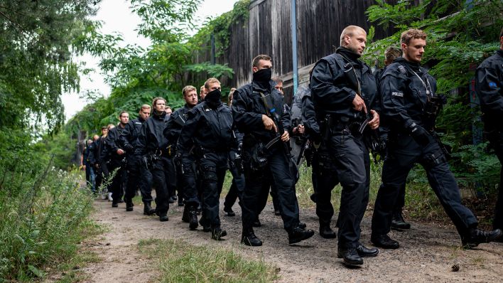 Polizisten laufen am 21.07.2023 im Bereich der südlichen Landesgrenze von Berlin. (Quelle: Fabian Sommer)