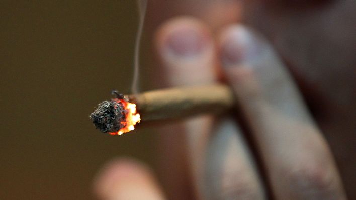 Symbolbild: Ein Joint mit Marihuana wird geraucht (Quelle: dpa/Oliver Berg)