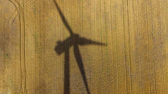 Symbolbild:Eine Windenergieanlage wirft einen Schatten auf ein Getreidefeld.(Quelle:picture alliance/spa/P.Pleul)