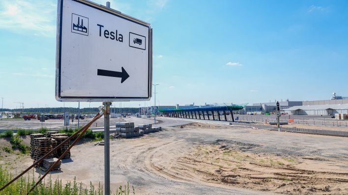 Grünheide, die Baustelle für die Erweiterung der Tesla Gigafactory im märkischen Grünheide in Brandenburg mit einem Schild als Wegweiser für die LKW-Zufahrt. (Quelle: dpa/Vladimir Menck)