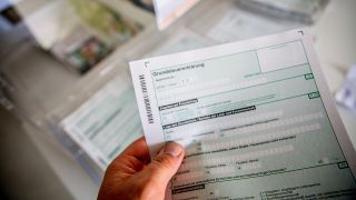 Symbolbild: Eine Person besorgt sich den Antrag in Papierform für die neue Grundsteuer in Deutschland (Quelle: IMAGO/K. Schmitt)