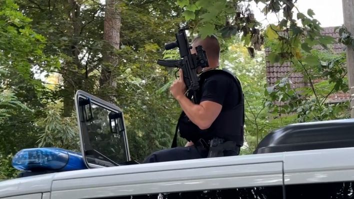 Ein Polizist mit Maschinenpistole auf dem Dach eines Polizeiwagens bei der Suche nach einer Löwin in Kleinmachnow (Quelle:rbb)