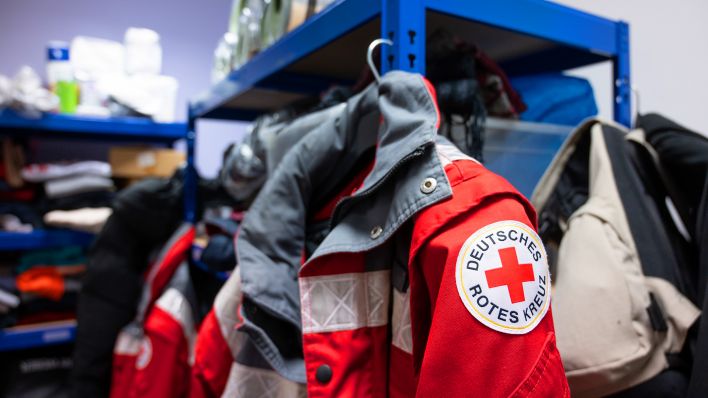 Symbolbild: Im Lager vom Deutschen Roten Kreuz hängt eine Jacke mit dem DRK-Logo. (Quelle: dpa/Christophe Gateau)