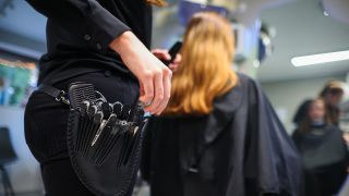 Symbolbild: Eine Friseurmeisterin schneidet in einem Salon einer Kundin die Haare. (Quelle: dpa/Jan Woitas)