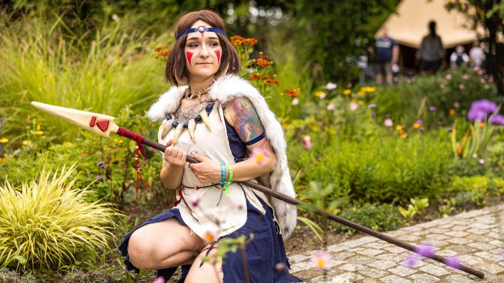 Eine Teilnehmerin des Elbenwaldfestivals posiert am 11.08.2023 mit ihrem aufwendig gestalteten Kriegerinnenkostüm. (Quelle: dpa/Frank Hammerschmidt)