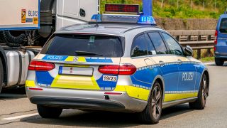 Symbolbild:Ein Einsatzfahrzeug der Polizei, Streifenwagen steht mit Blaulicht und Schriftzug an einem Unfallort auf der Autobahn.(Quelle:picture alliance/Fotostand/Reiss)