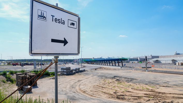 Die Baustelle für die Erweiterung der Tesla Gigafactory in Grünheide mit einem Schild als Wegweiser. (Quelle: dpa/Vladimir Menck)