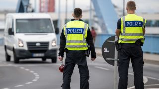 Zwei Polizisten stehen an der deutsch-polnischen Grenze. (Quelle: dpa/Hannes P Albert)