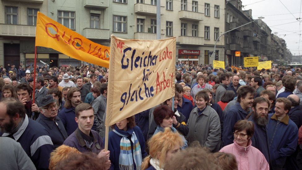 Archivfoto: Gleichen Lohn für gleiche Arbeit fordern die Arbeitnehmer der IG Metall am 28.02.1991 auf einer Großkundgebung in der Edison-/Ecke Wilhelminenhofstraße in Oberschöneweide (Quelle: dpa / Peer Grimm)..
