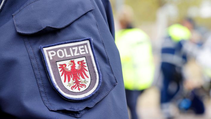 Symbolbild: Wappen der Polizei Brandenburg an der Polizeiuniform. (Quelle: IMAGO/Sebastian Gabsch)
