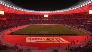 Das rot angestrahlte Olympiastadion. (Bild: IMAGO / Matthias Koch)
