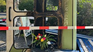 Auf die Bücherboxx Gleis 17 am S-Bahnhof Grunewald wurde am 12.08.2023 mutmaßlich ein Brandanschlag verübt. Am Tag danach stehen Blumen vor der Büchertauschbox. (Quelle: rbb24/Winkler)