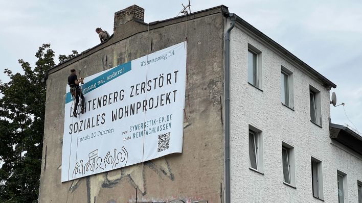 Am 12.08.2023 hängten Menschen ein Plakat an die Brandschutzmauer des Gebäudes im Wiesenweg 14 in Berlin-Lichtenberg. (Quelle: rbb|24/Oliver Noffke)