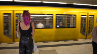 Frau steht vor Berliner U-Bahn