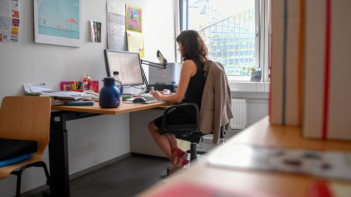 Symbolbild: Eine Mitarbeiterin sitzt an ihrem Schreibtisch im Bezirksamt (Quelle: dpa/Britta Pedersen)