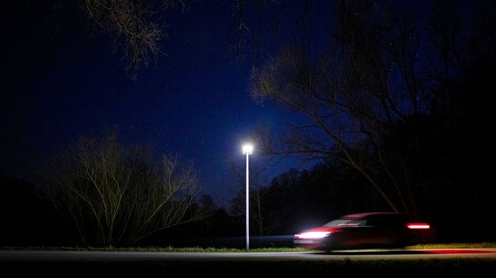Symbolbild: Eine Straßenlaterne leuchtet an einem Waldstück (Quelle: dpa/Florian Gaertner)