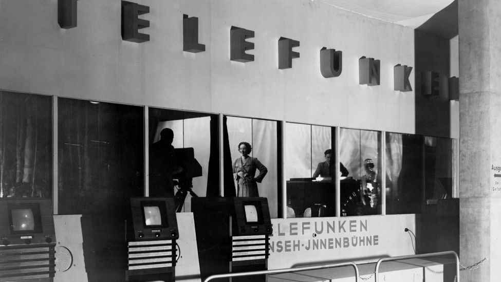 Direktübertragung von Fern- sehaufnahmen einer musikalischen Dar- bietung auf die aufgestellten Empfangs- geräte (375 Zeilen bei 25 Bildwechseln pro Sekunde) auf der Funkausstellung 1963 in Berlin. (Quelle: Picture Alliance/akg-images)