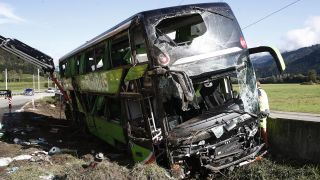 Der verunglückte Reisebus liegt im Graben. Bei einem Busunfall im österreichischen Bundesland Kärnten ist eine Frau ums Leben gekommen (Quelle: dpa/APA/Gert Eggenberger).
