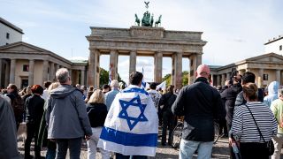 Menschen nehmen am 08.10.2023 an einer Solidaritätsdemo für Israel auf dem Pariser Platz am Brandenburger Tor teil (Quelle: dpa / Fabian Sommer).