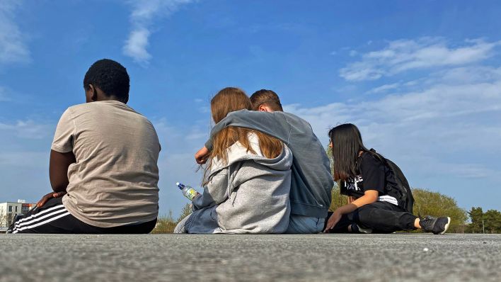 Symbolbild:Jugendliche sitzen in einem Park auf dem Boden.(Quelle:picture alliance/SvenSimon)