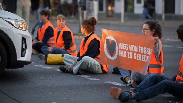 Aktivisten der Klimaschutzgruppe Letzte Generation sitzen während einer Straßenblockade auf dem Mehringdamm am 19.09.2023.(Quelle:dpa/S.Gollnow)