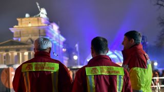 Symbolbild: Einsatzkräfte der Berliner Feuerwehr stehen am 31.12.2016 in Berlin auf der Festmeile vor dem Brandenburger Tor. (Quelle: dpa-Zentralbild/Britta Pedersen)