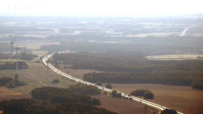 Autos fahren auf der Autobahn 24. Daneben stehen Windräder. (Foto: dpa)
