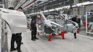 Mitarbeiter der Tesla Gigafactory Berlin Brandenburg arbeiten an einer Fertigungslinie eines Elektrofahrzeuges vom Typ Model Y. (Quelle: dpa/Patrick Pleul)