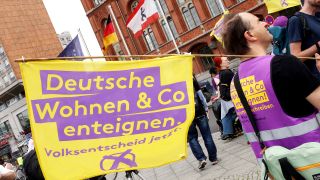 Archivbild: Ein Demonstrant hält eine Fahne mit der Aufschrift «Deutsche Wohnen und Co enteignen» während einer Kundgebung vor dem Roten Rathaus. (Quelle: dpa/W. Kumm)