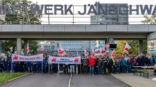 Archivbild: Streikende Beschäftigte des Kraftwerkes Jänschwalde stehen mit Transparenten und Fahnen vor dem Werkstor. (Quelle: dpa/Hammerschmidt)
