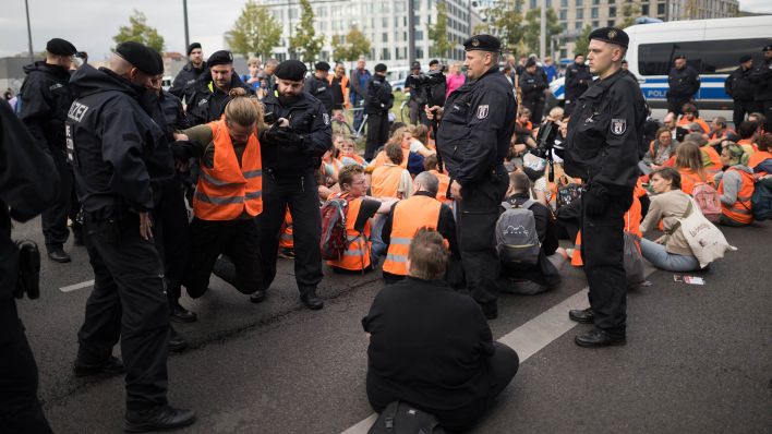 Archivbild: Polizisten tragen während eines Protestmarsches der Klimaschutzgruppe «Letzte Generation» einen Teilnehmer vor dem Hauptbahnhof von der Straße. (Quelle: dpa/S. Gollnow)