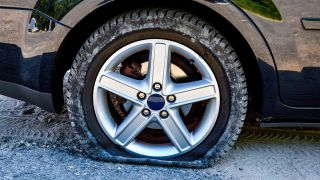Symbolbild: Platter Reifen an einem Auto. (Quelle: dpa/C. Ohde)
