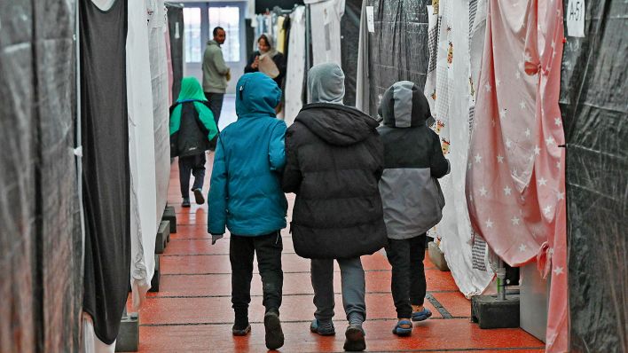 Symbolbild:Flüchtlingskinder gehen durch ein Zelt der Flüchtlingsunterkunft.(Quelle:dpa/A.Dedert)