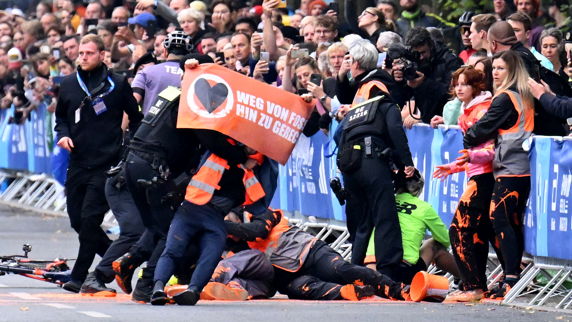 Aktivisten der Klimaschutzgruppe "Letzte Generation" werden am 24.09.2023 bei einer Berliner-Marathon-Protestaktion von Polizisten gestoppt (Quelle: dpa/Sebastian Christoph Gollnow)