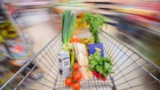 ILLUSTRATION - Ein mit Lebensmittel gefüllter Einkaufswagen wird durch einen Supermarkt geschoben. (Foto: dpa)