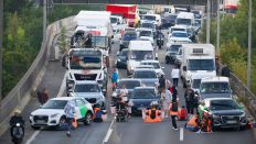 28.09.2023, Berlin: Aktivisten stehen während einer Straßenblockade der Klimaschutzgruppe Letzte Generation auf der A100. (Quelle: dpa/Sebastian Gollnow)