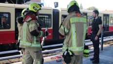 Feuerwehrleute und ein Polizist stehen nach einem Unfall am 10.09.2023 auf dem S-Bahnhof Mahlsdorf. (Quelle: dpa-Bildfunk/John Boutin)