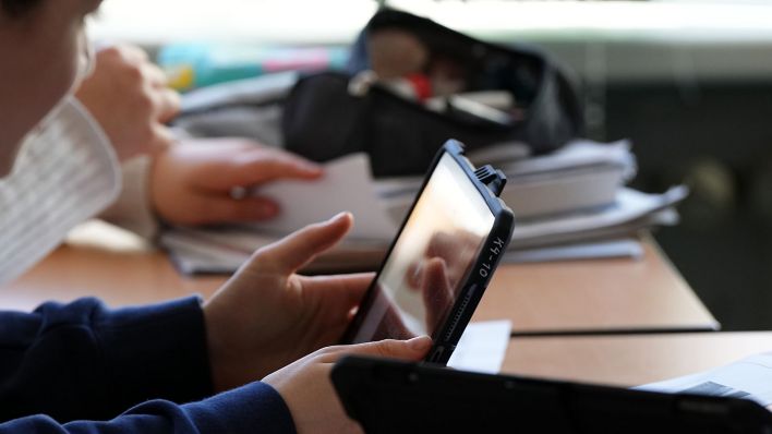 Ein Schüler hält im Klassenzimmer ein Tablet in der Hand. (Quelle: dpa/Soeren Stache)
