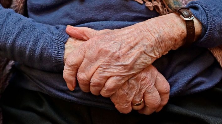 Symbolbild:Eine ältere Frau hält ihre Hände überkreuzt vor ihren Körper.(Quelle:imago images/R.Lueger)