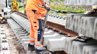 Symbolbild: Ein Gleisarbeiter steht an einem Gleis auf einer Schwelle. (Quelle: imago images/dts)