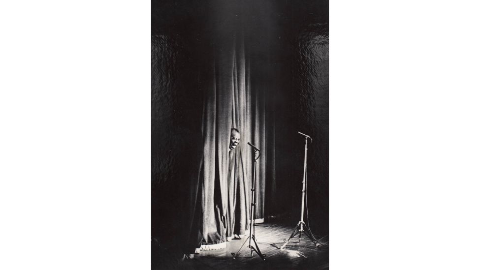 Louis Armstrong blickt durch den Bühnenvorhang des Berliner Friedrichstadt-Palastes bei seinem Konzert am 20.3.1965. (Quelle: DDR Fotoerbe/Helmut Raddatz)