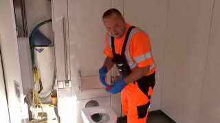 Reinigungskraft vor Berliner Toilette