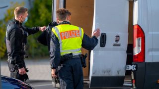 Zwei Polizisten kontrollieren auf der Grenzbrücke zwischen Deutschland und Polen ein Fahrzeug nach illegalen Einreisenden. (Quelle: dpa/Monika Skolimowska)