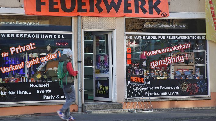 Symbolbild: Ein Mann geht am 23.11.2020 im Bezirk Köpenick an einem Geschäft vorbei, in dem Berechtigte und Gewerbetreibende für Veranstaltungen ganzjährig Feuerwerk kaufen können. (Quelle: Picture Alliance/Wolfgang Kumm)