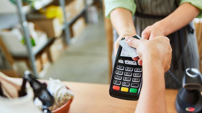 Symbolbild: Ein Kunde bezahlt am 15.10.2021 mit Kreditkarte an der Kasse im Einzelhandel kontaktlos über NFC. (Quelle: Picture Alliance/Zoonar.com/Robert Kneschke)