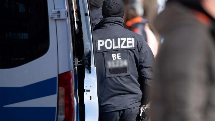Symbolbild: Ein Polizist an seinem Einsatzfahrzeug. (Quelle: dpa/Stephan Schulz)