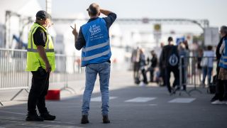 Helfer und Sicherheitskräfte stehen in der Notunterkunft für Geflüchtete am ehemaligen Flughafen Tegel (Quelle: dpa/Sebastian Gollnow).